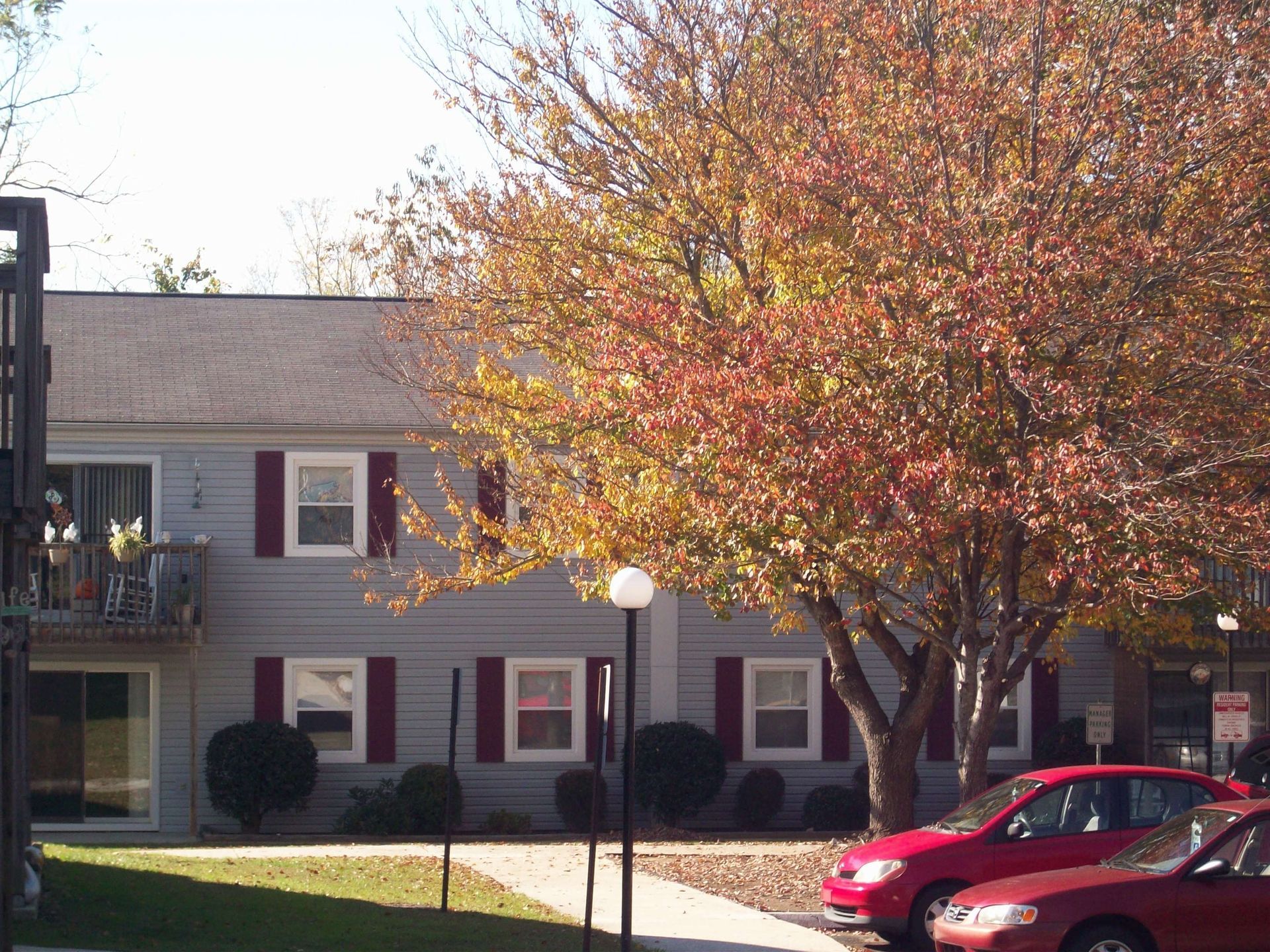 Two red cars are parked in front of a house