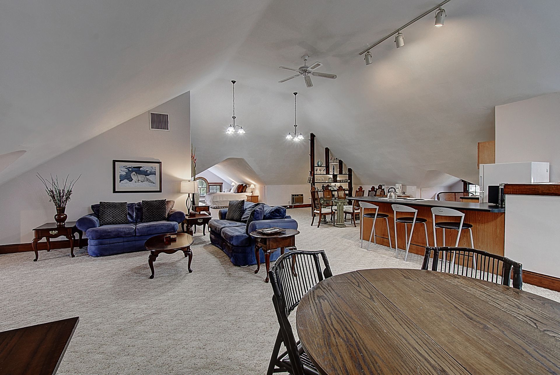 A living room with a blue couch and a wooden table
