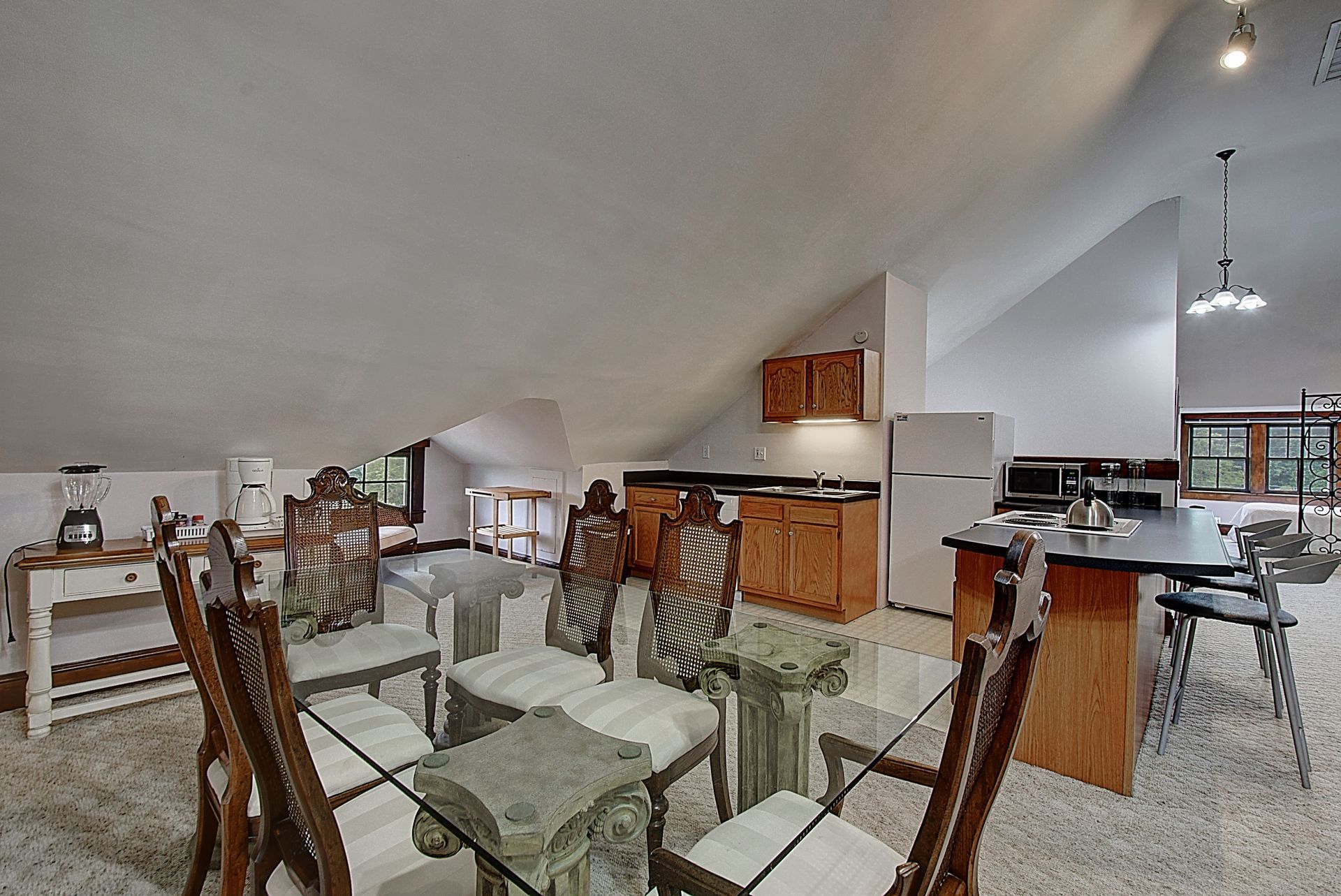 A kitchen with a glass dining table and chairs