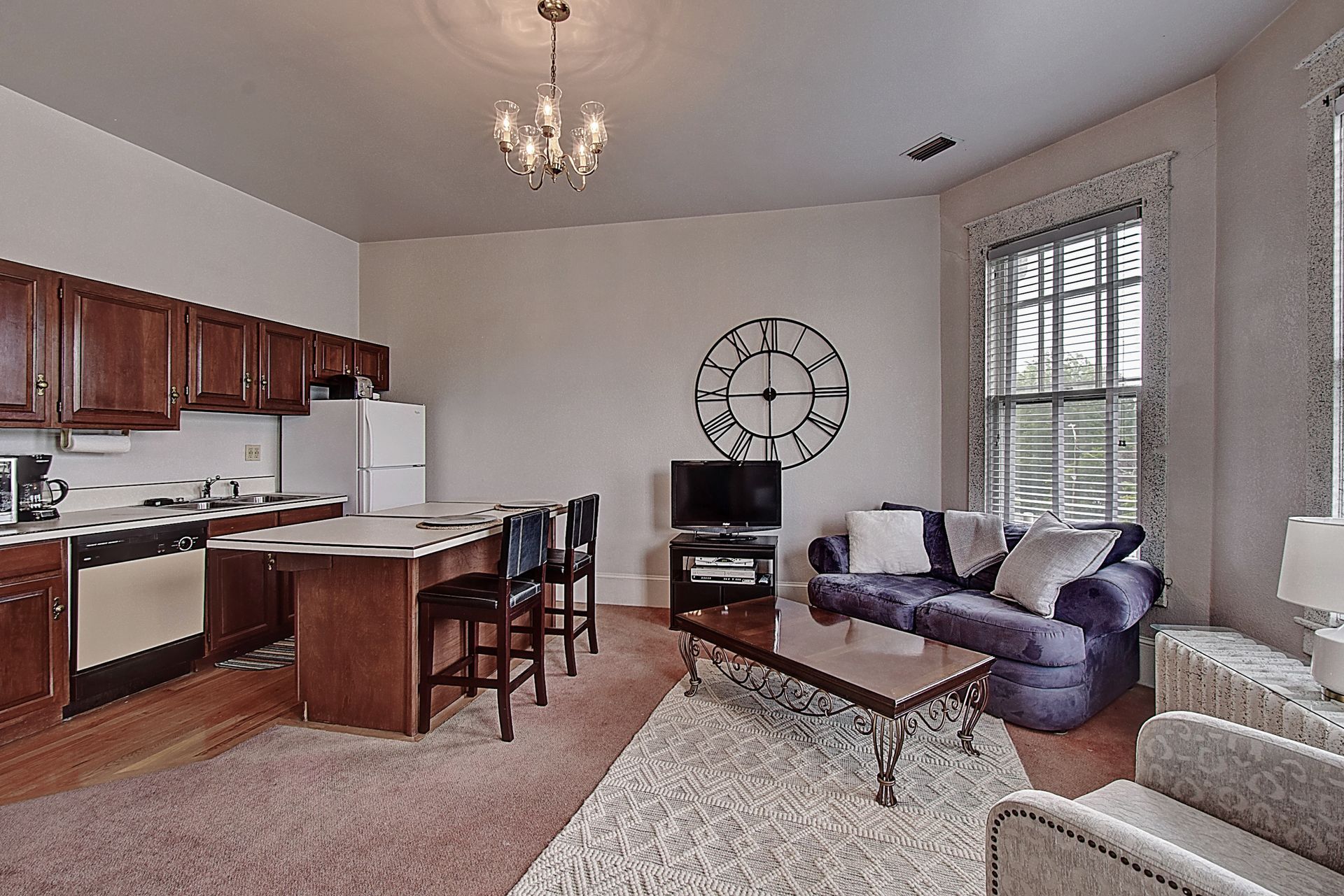 A living room with a couch and a clock on the wall