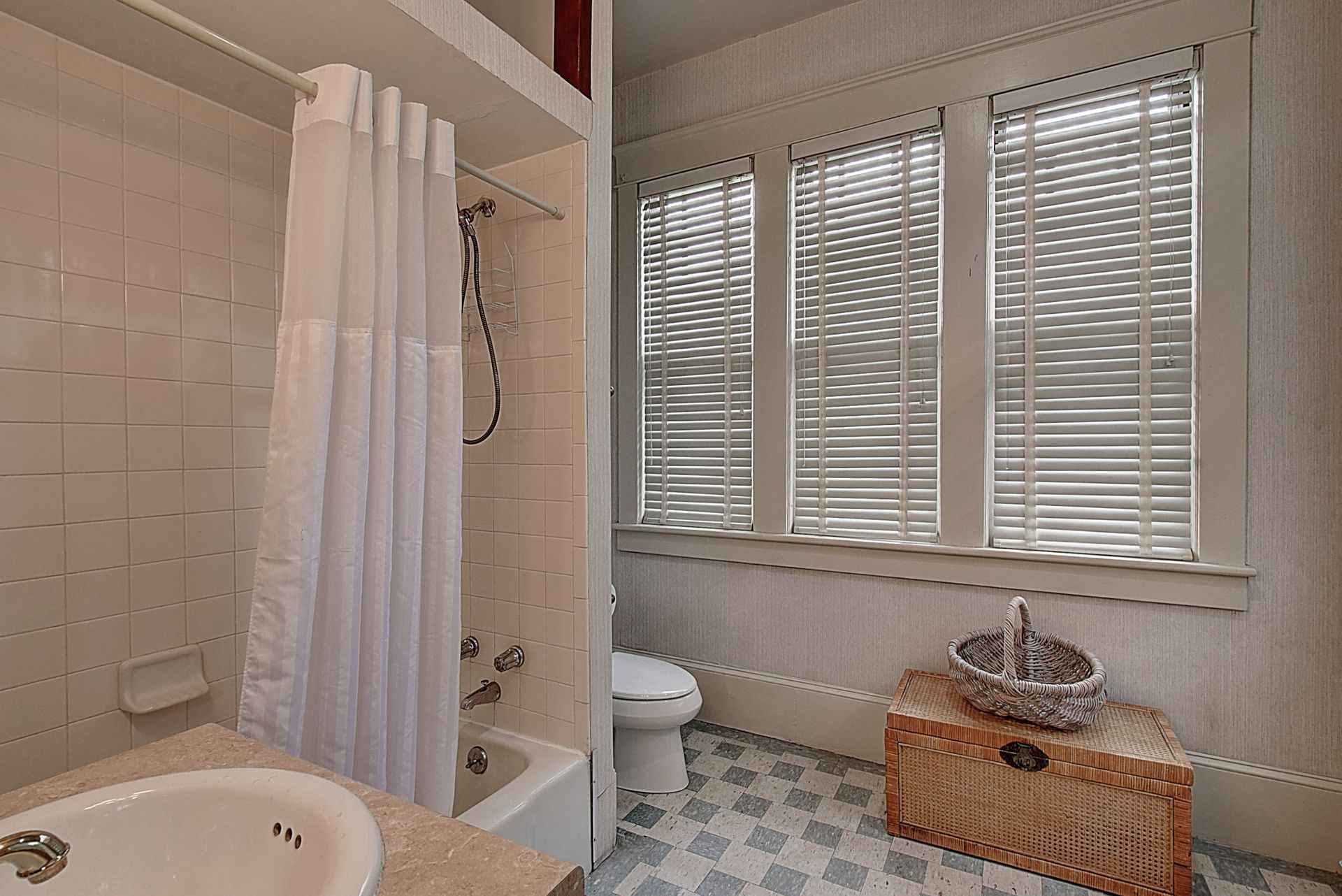 A bathroom with a sink a toilet and a shower curtain