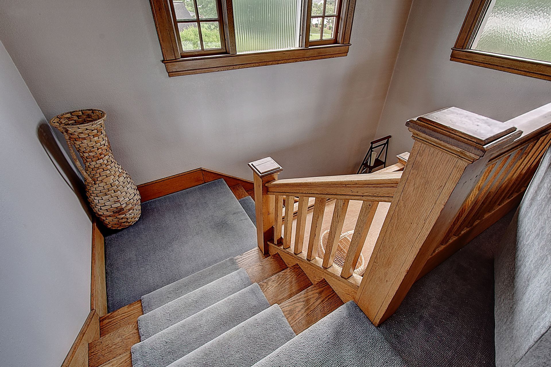 A staircase with a wooden railing and carpeted steps