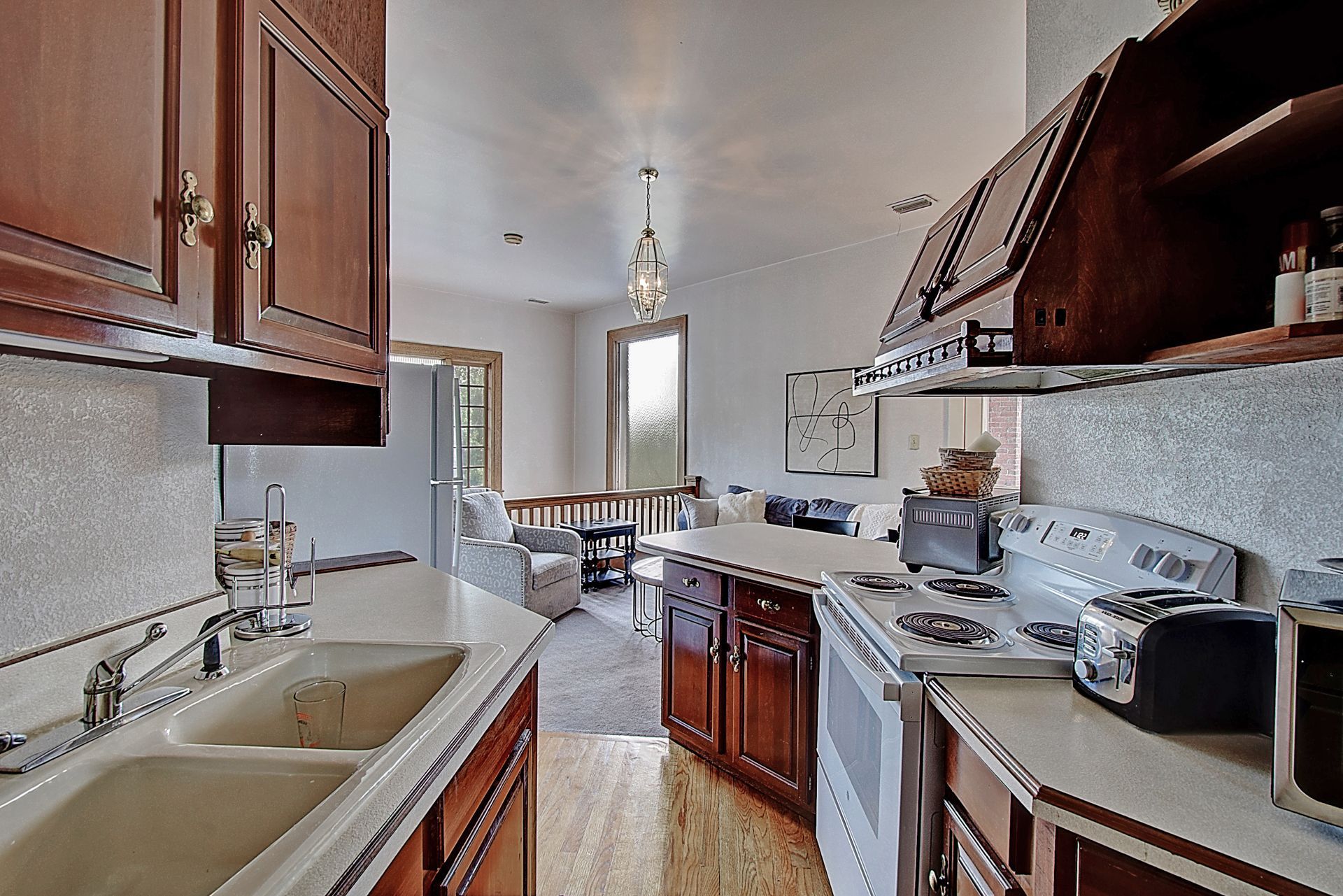 A kitchen with a sink stove and a microwave