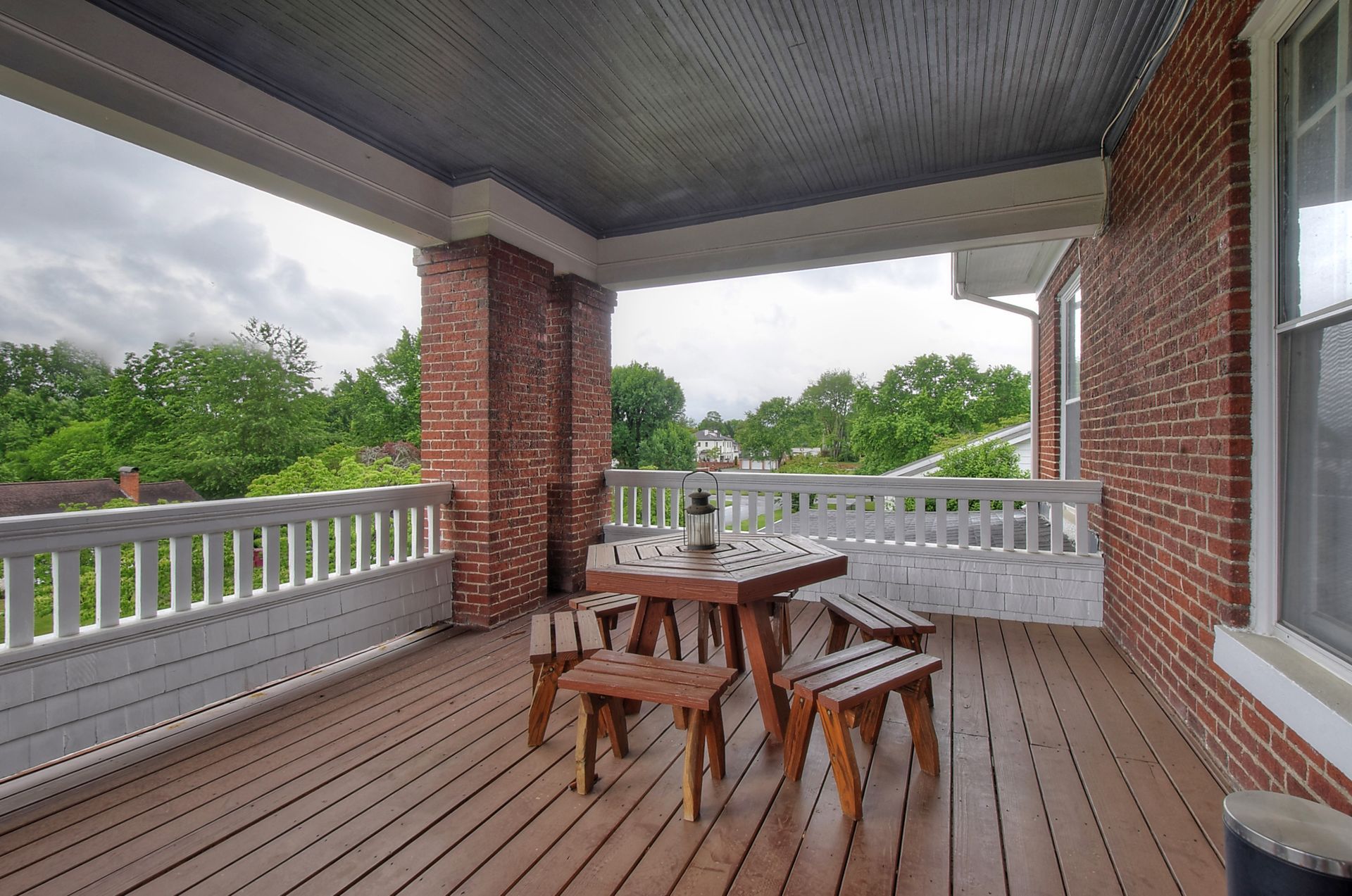 A porch with a table and benches on it