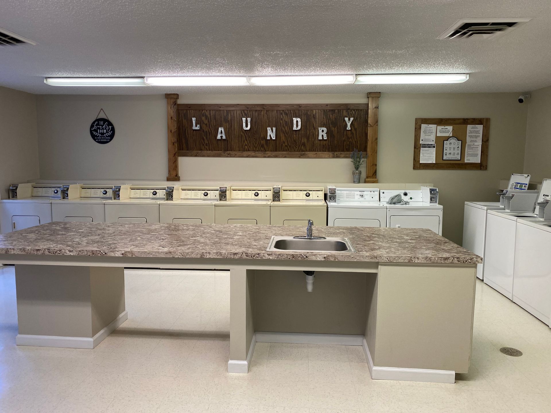 A laundry room with a sink , washers and dryers.