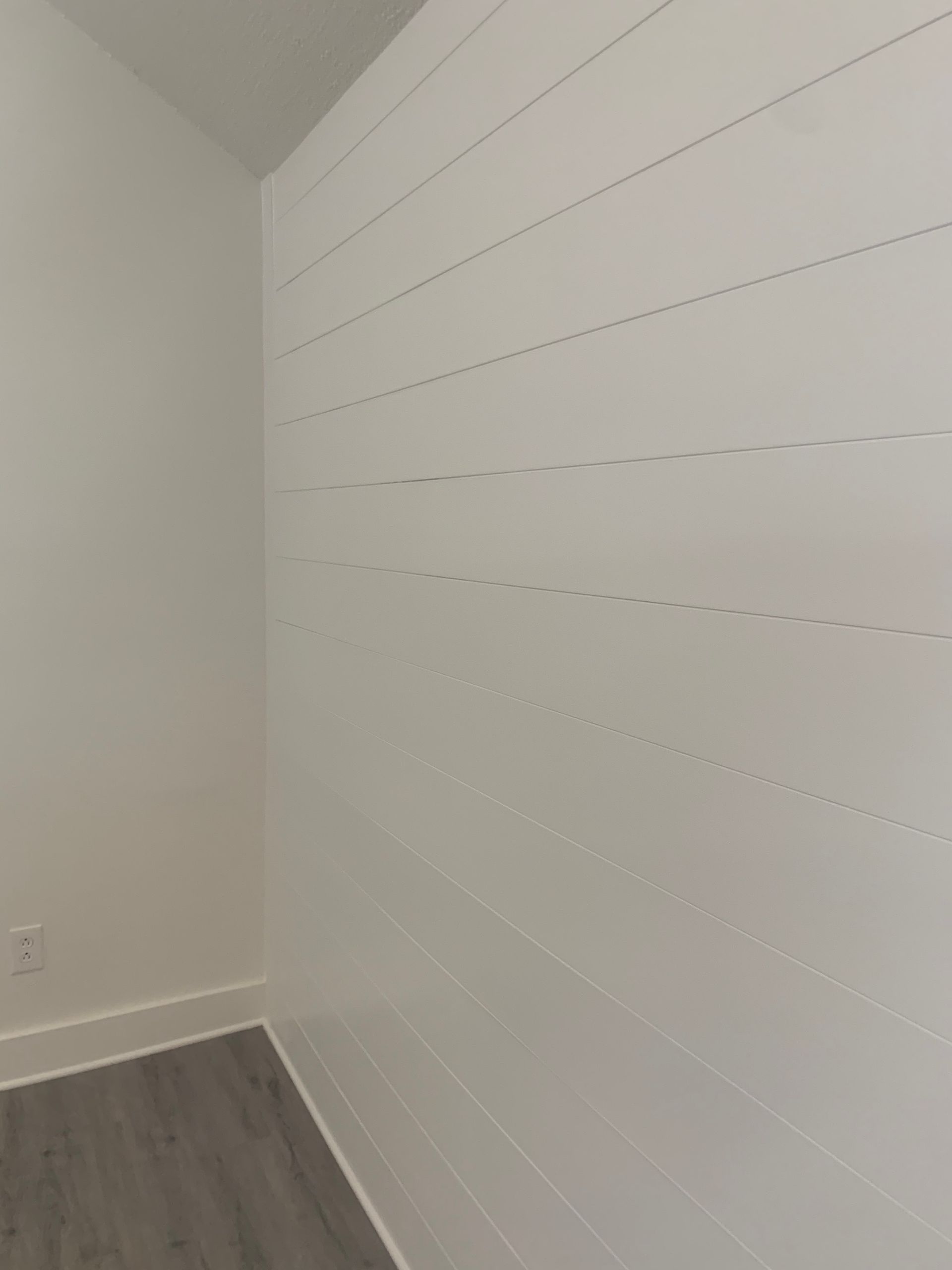 A room with white walls and a wooden floor.