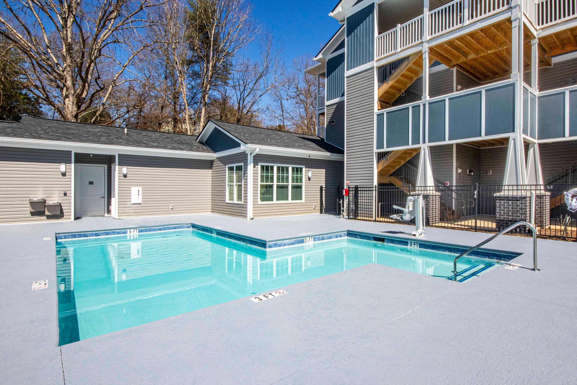 There is a large swimming pool in front of a building.