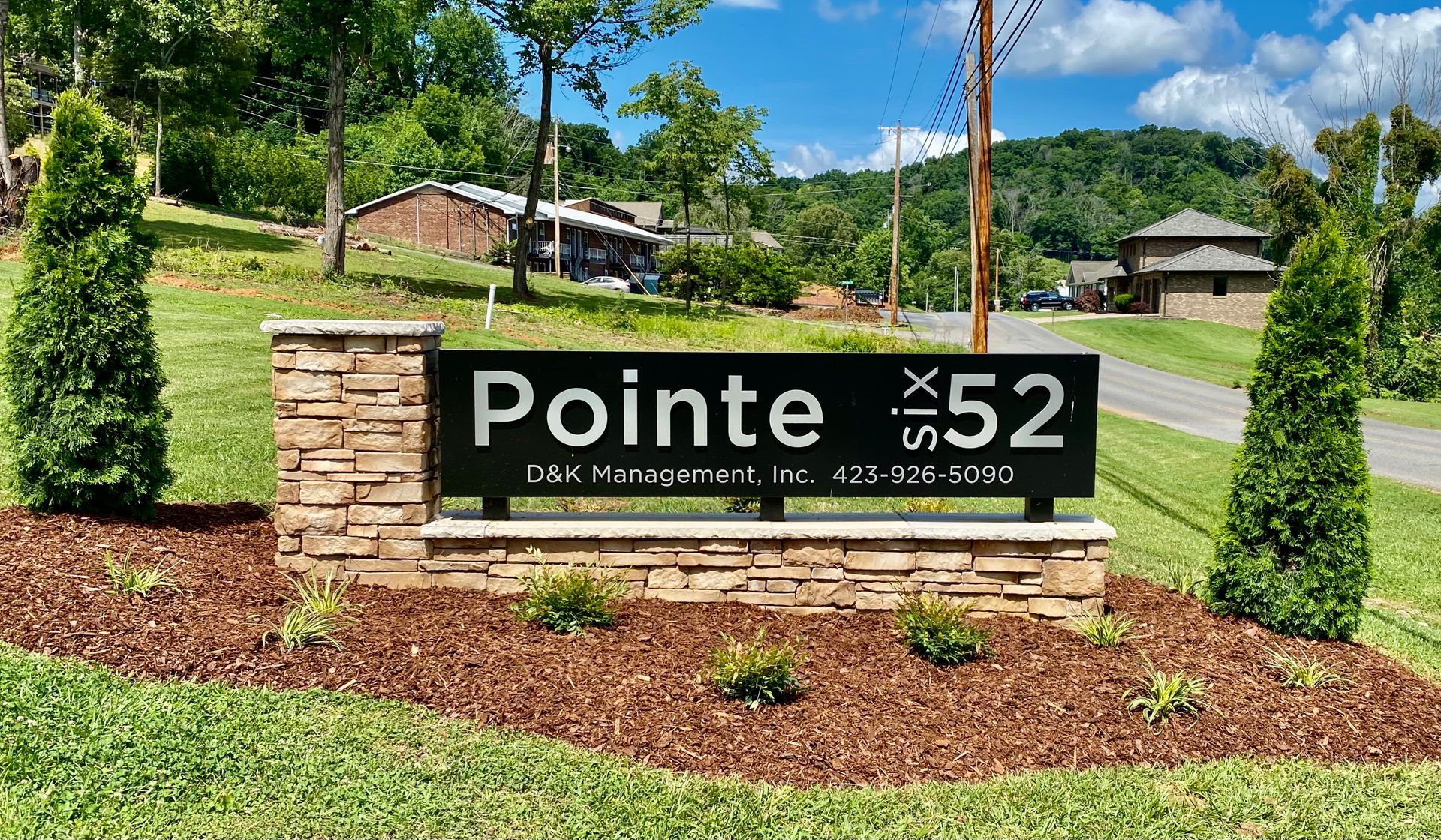 A sign for pointe 52 is in the middle of a lush green field.