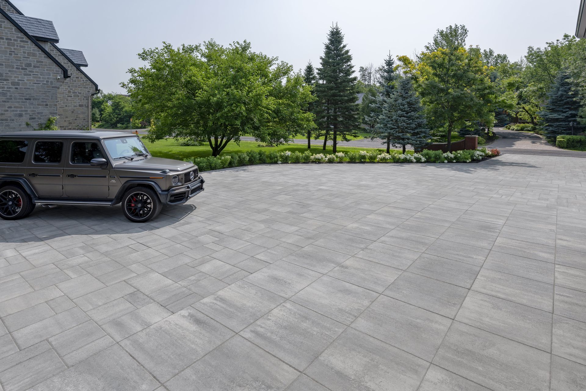 Une jeep est garée dans une allée avec des arbres en arrière-plan.