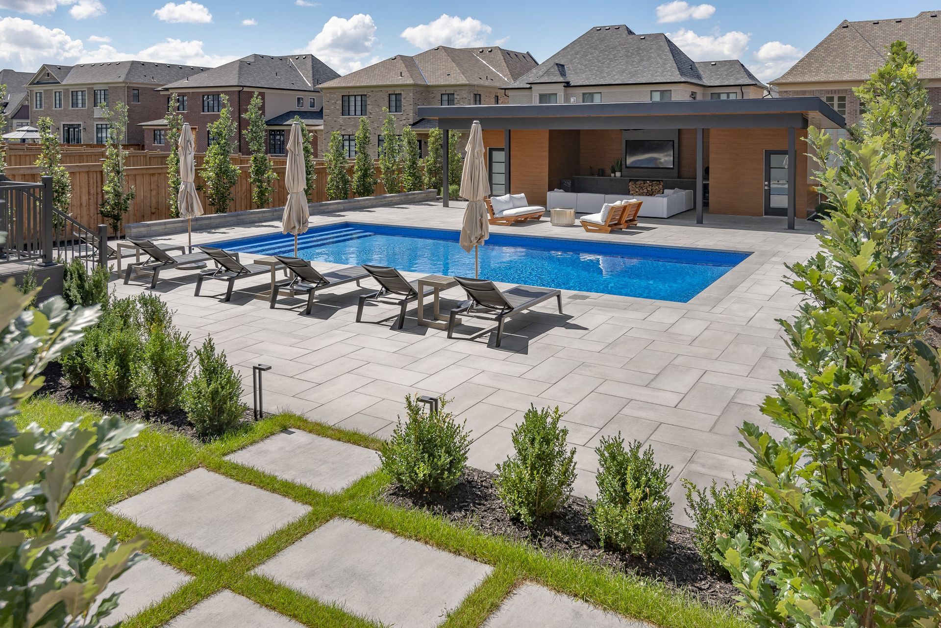 A large swimming pool surrounded by chairs and umbrellas