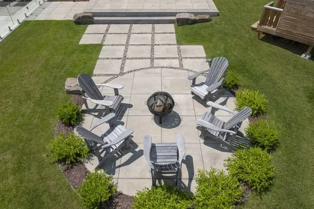 Une vue aérienne d'un patio avec des chaises et un foyer.