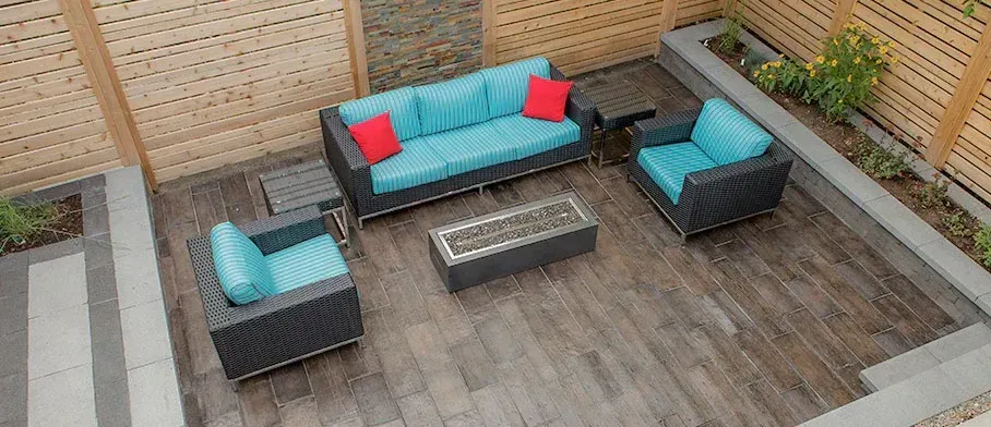 Une vue aérienne d'un patio avec un canapé, des chaises et un foyer.