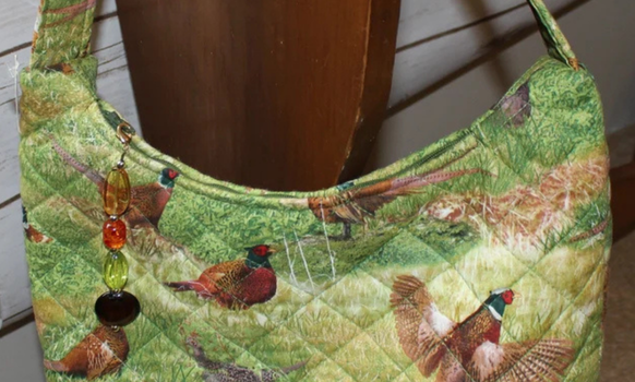 Quilted fabric purse with a pheasant print, green and brown colors, with beaded embellishment.