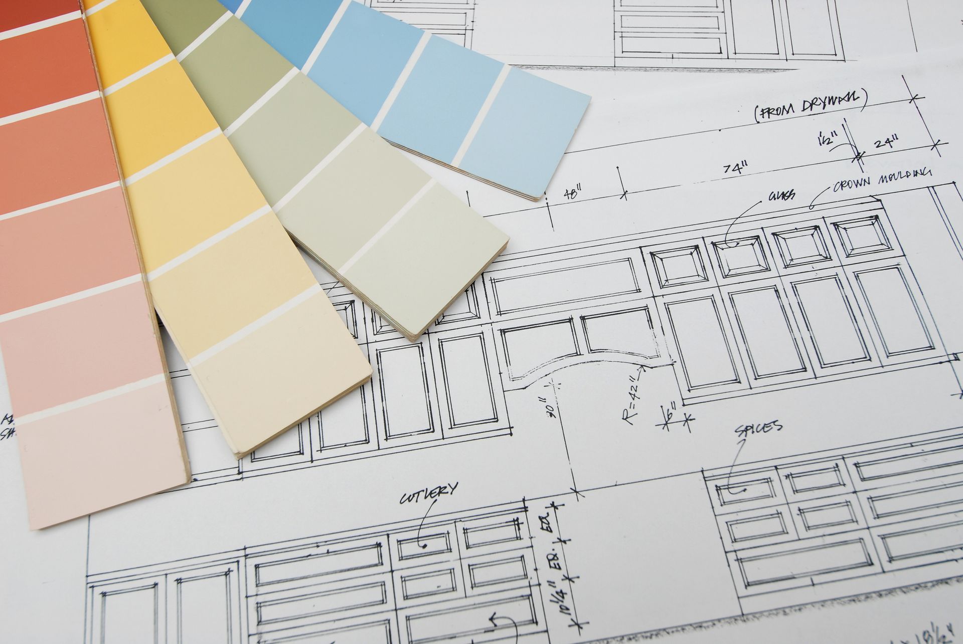 Kitchen blueprint with labeled sections and colorful paint swatches laid on top.