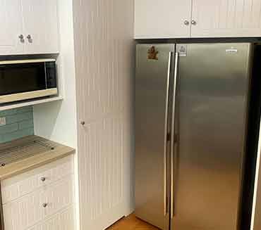 A kitchen with a stainless steel refrigerator , microwave , and cabinets.