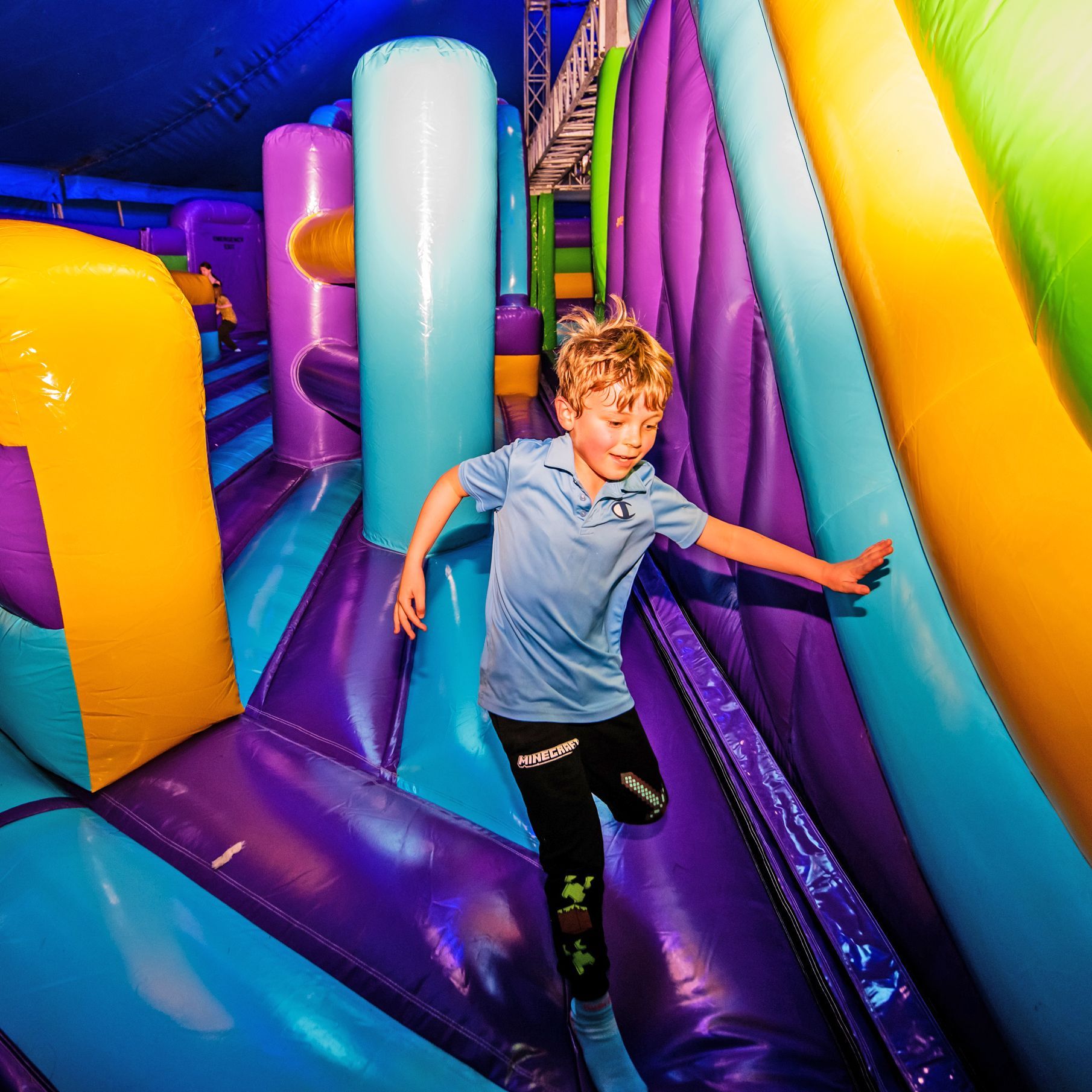 A young boy is playing in a bouncy house.