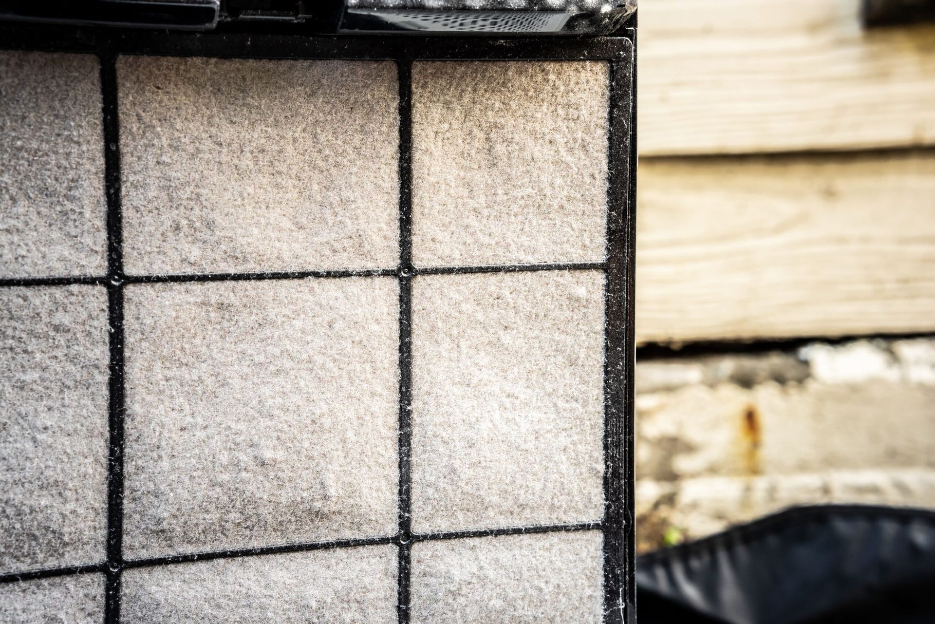 A close-up view of a frosted, grid-patterned surface, likely a cooling element, with a blurry background.