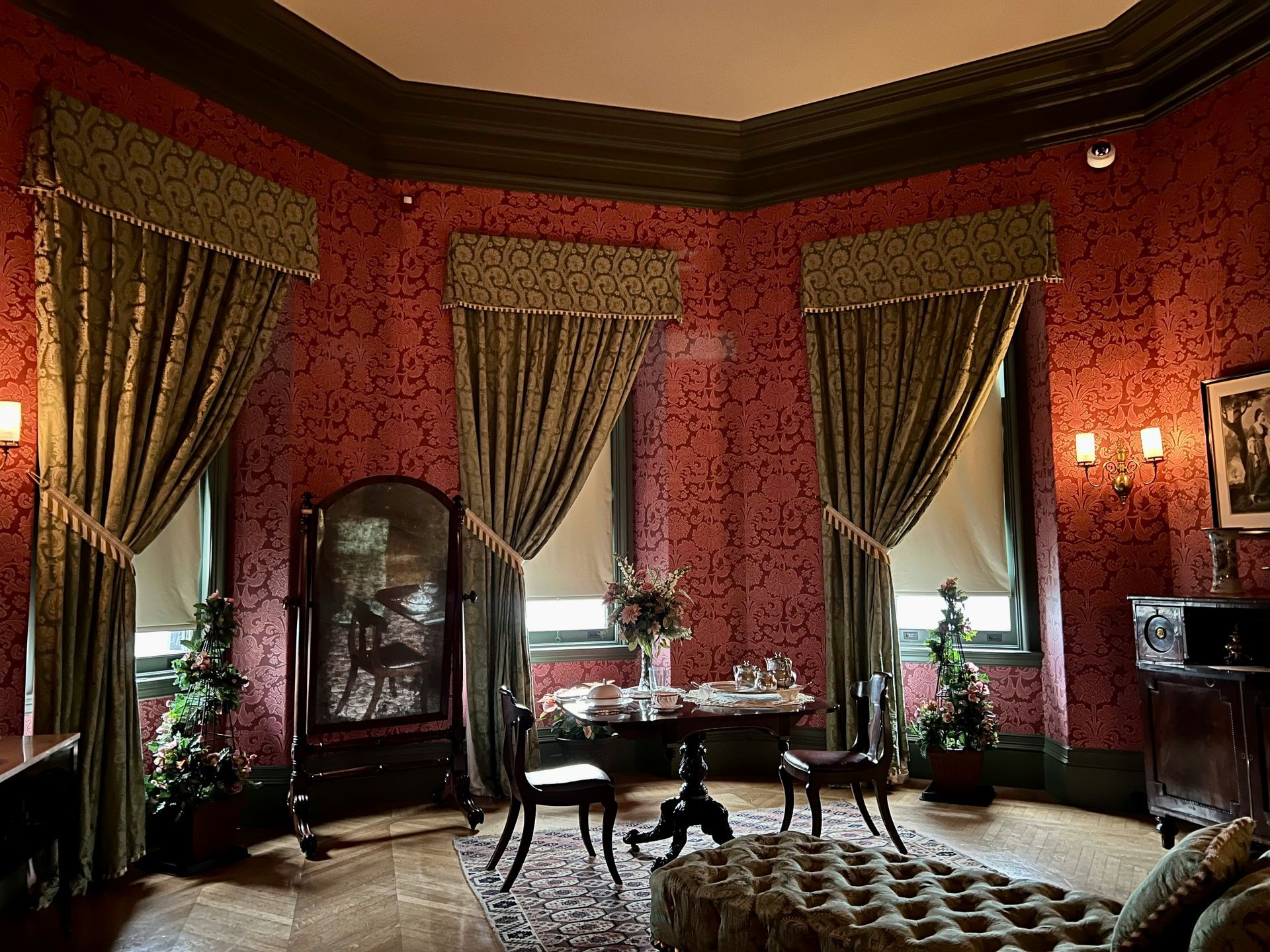 A living room with red walls and green curtains