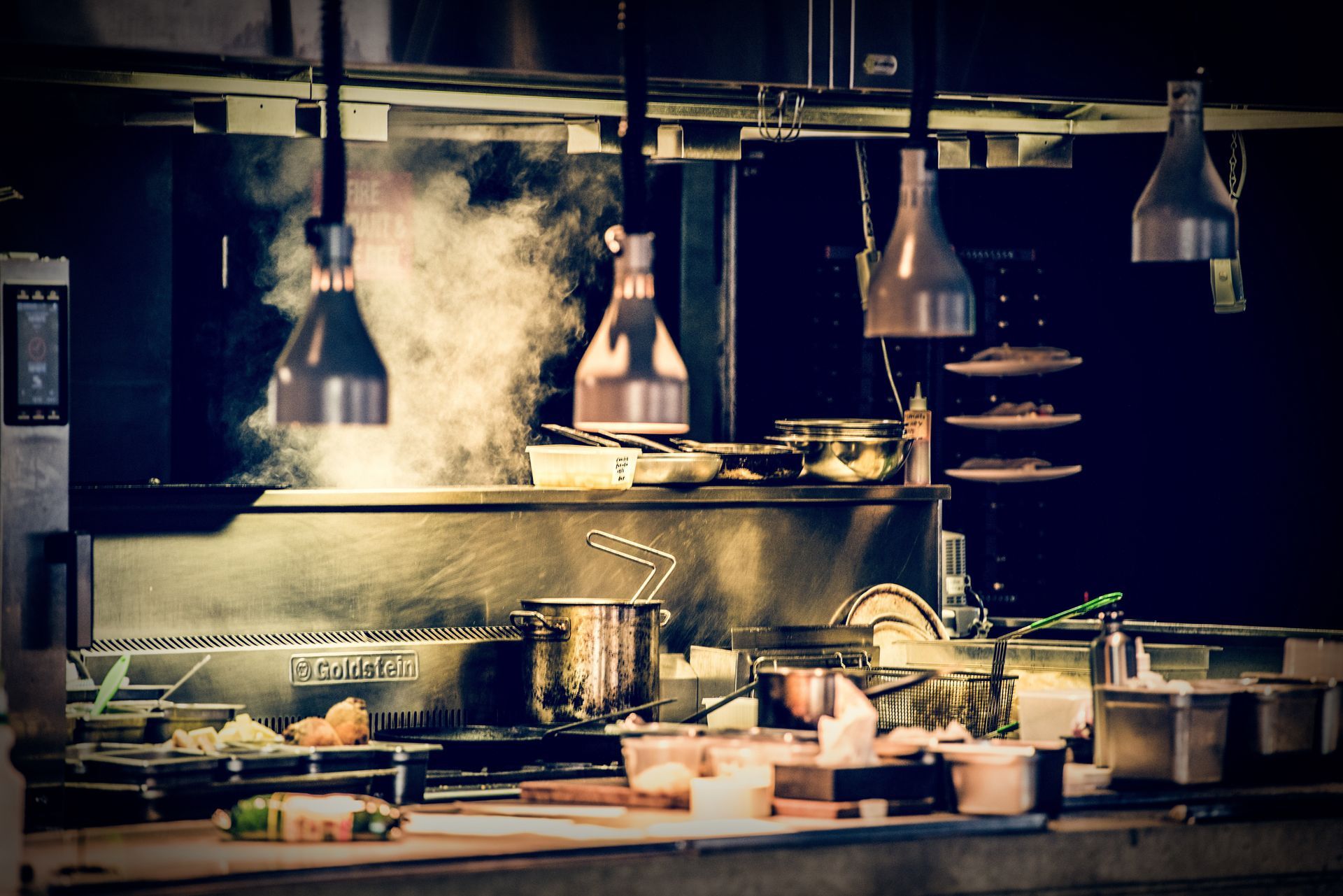 A kitchen with a lot of pots and pans on the stove.