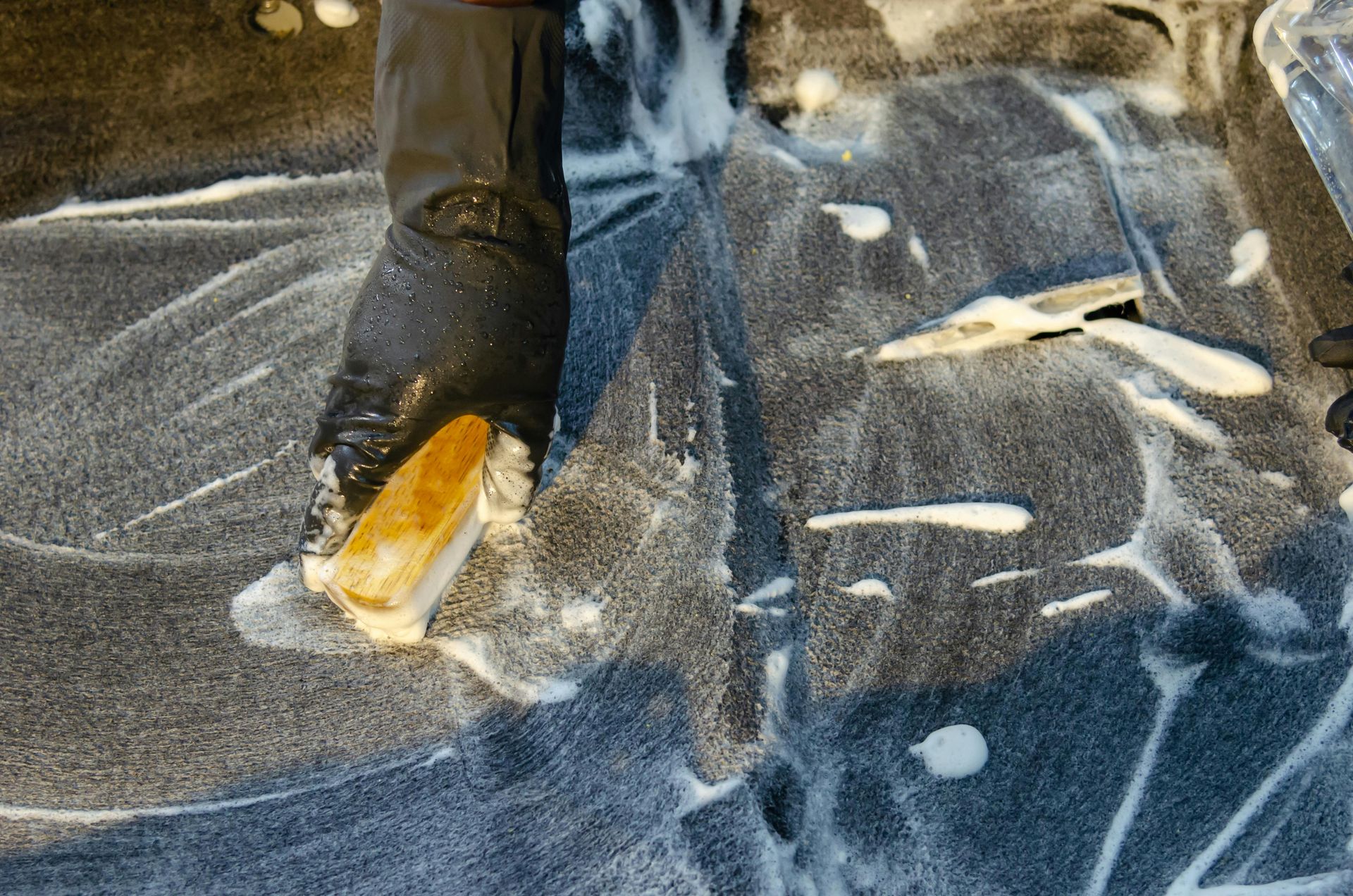 A person is standing on a carpet covered in foam.