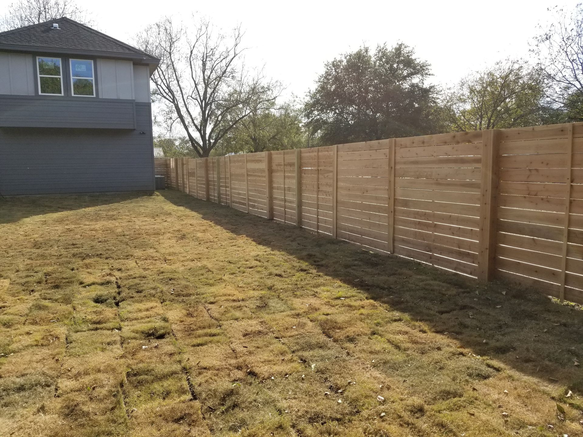 A house with a wooden fence in the backyard