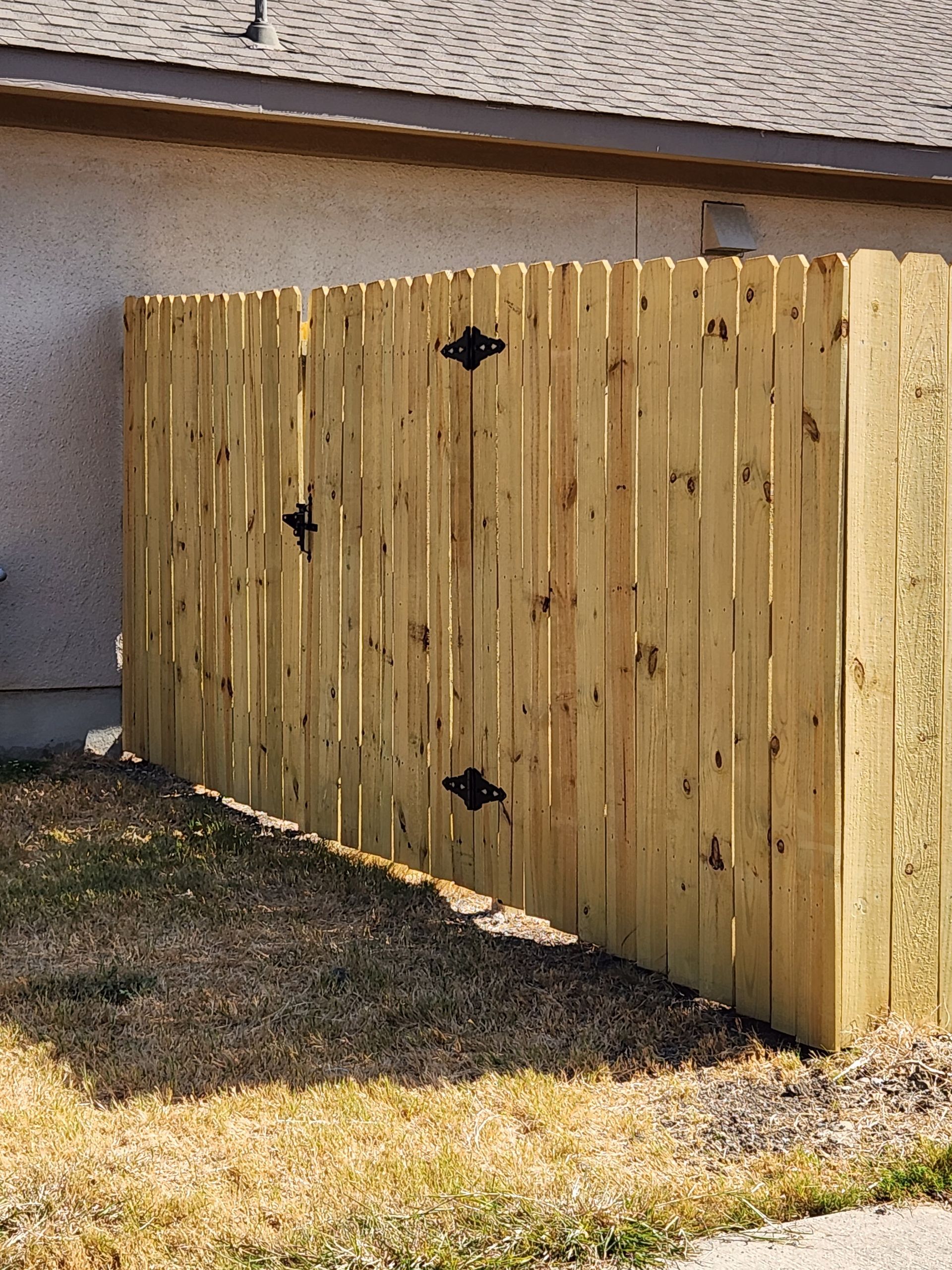 A wooden fence is sitting in front of a house