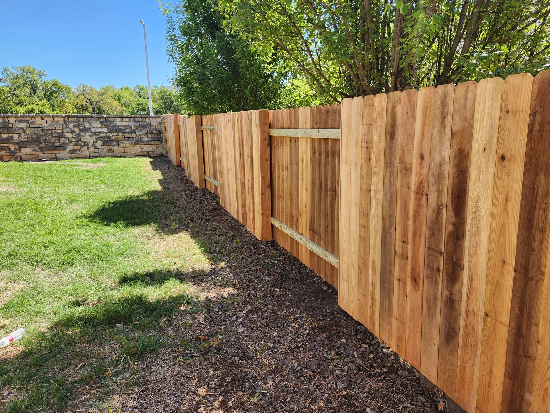 A wooden fence with a gate in the backyard of a house.
