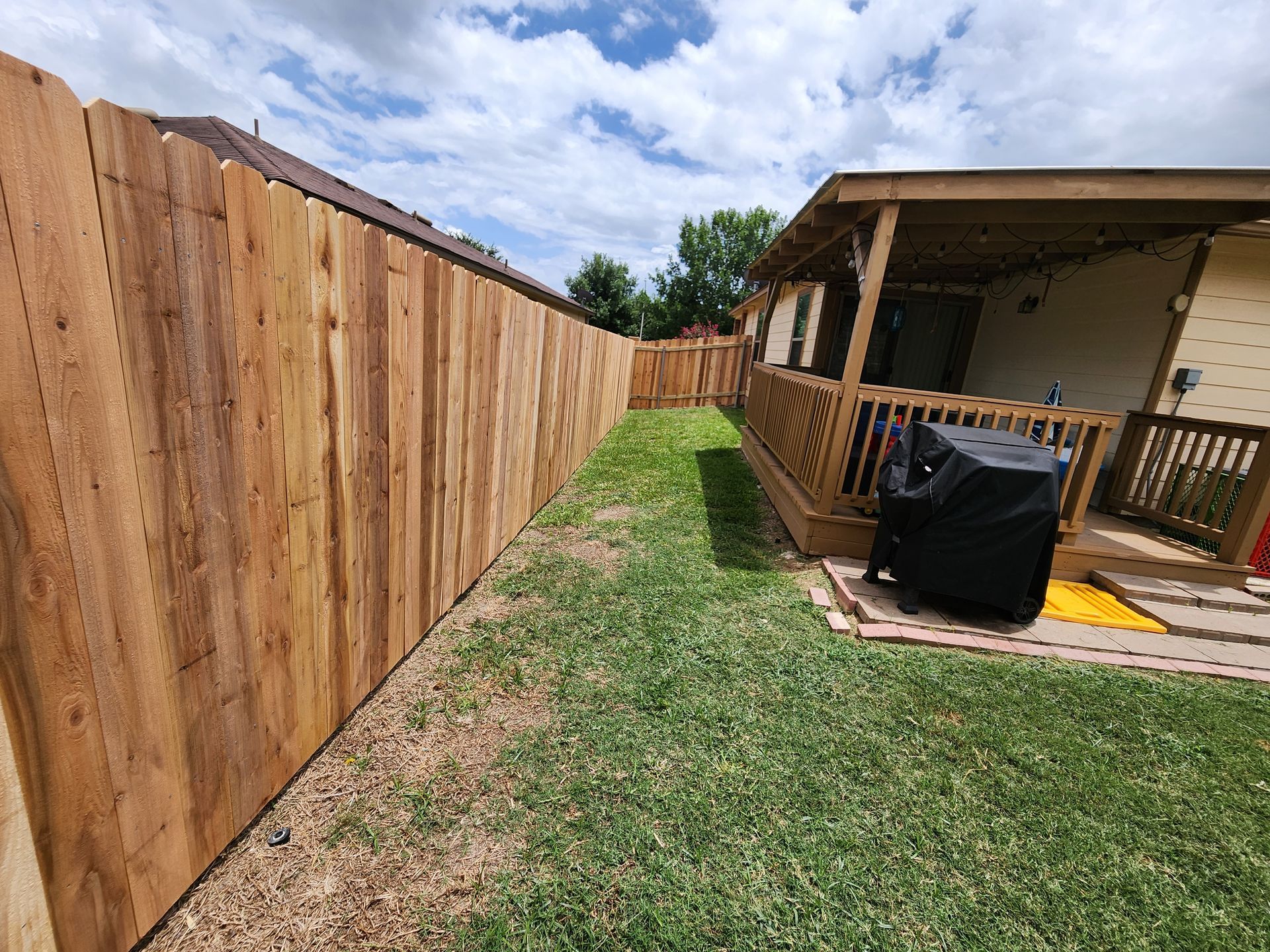 There is a wooden fence in the backyard of a house.