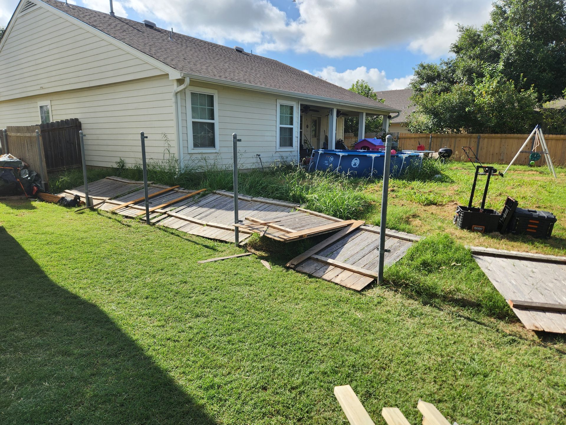 A backyard with a house and a pool in the background.