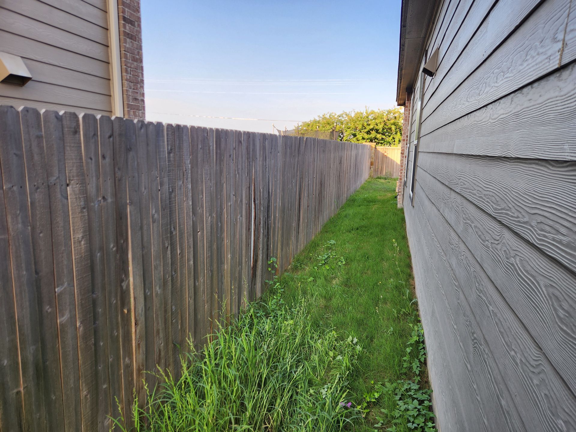 There is a wooden fence between two houses.