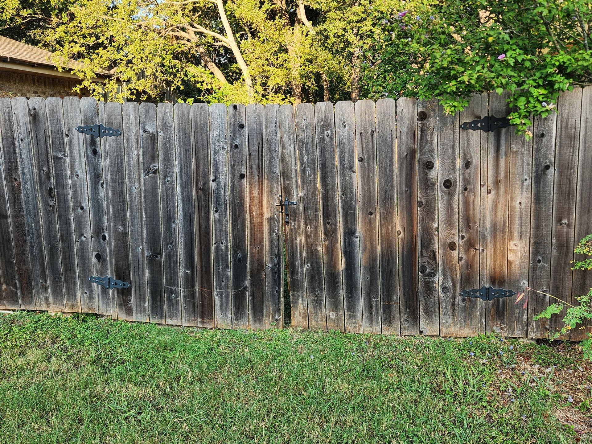 A wooden fence is sitting on top of a lush green lawn.