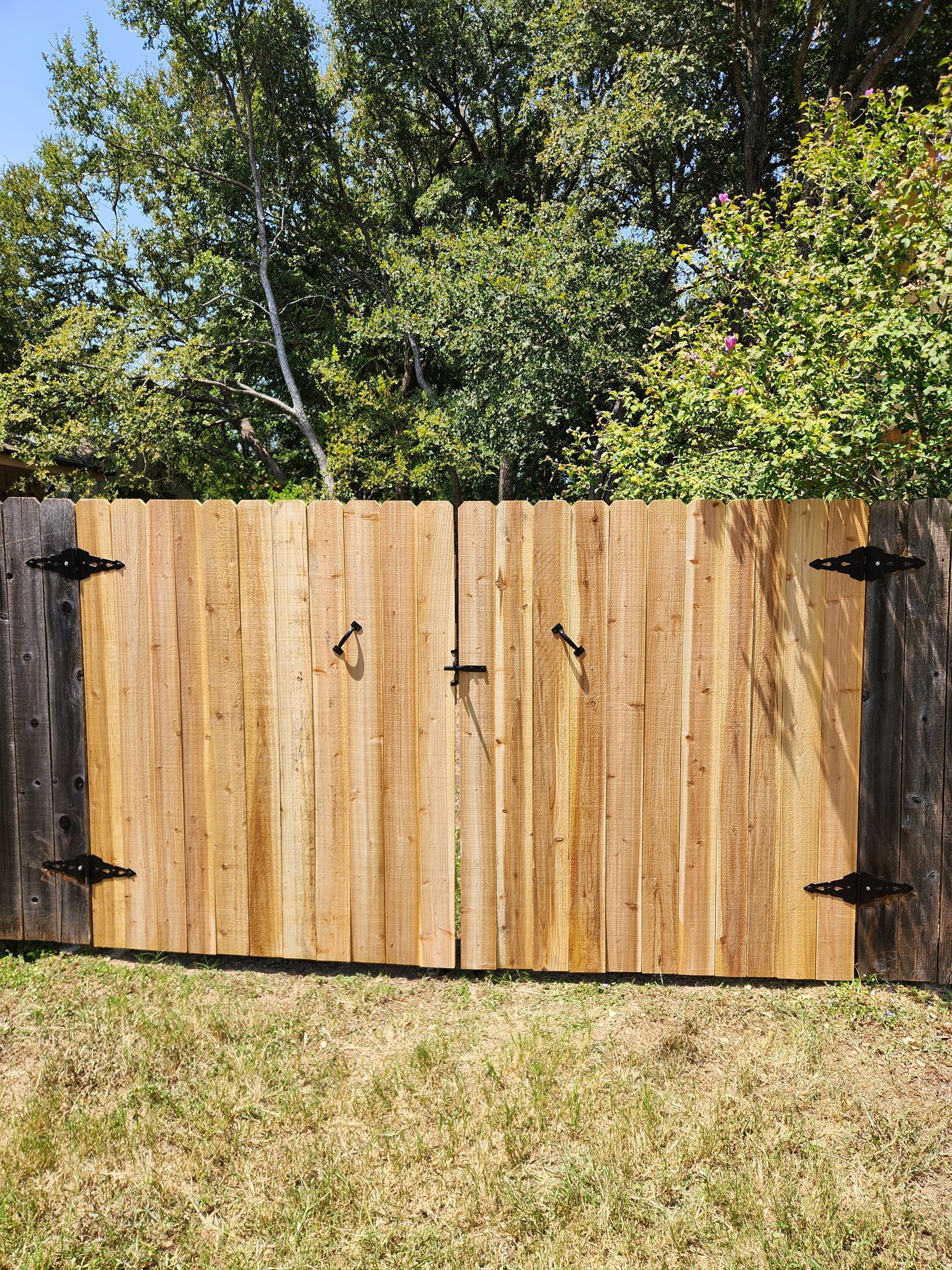 A wooden fence is sitting in the middle of a grassy field.