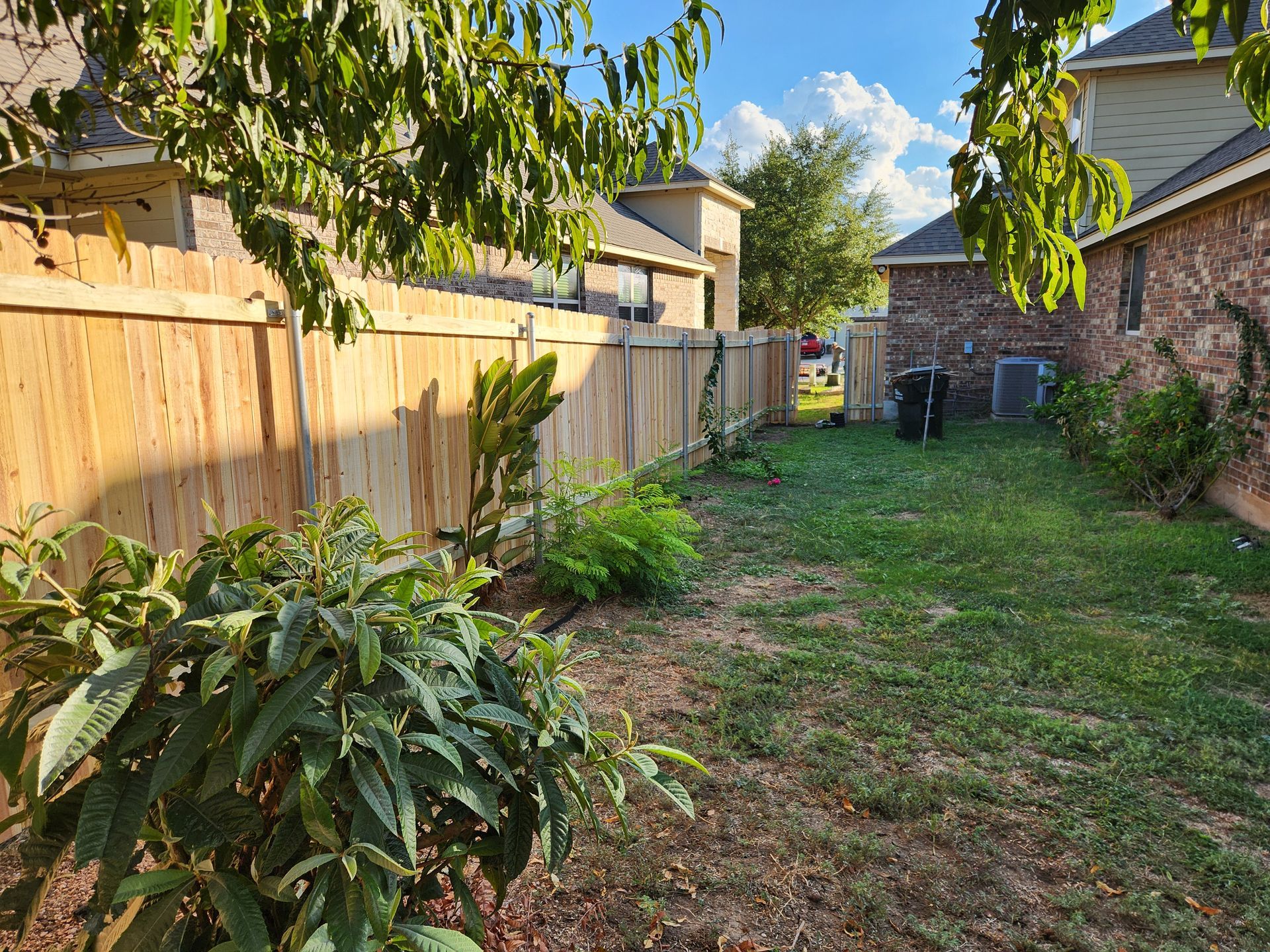 There is a wooden fence in the backyard of a house.