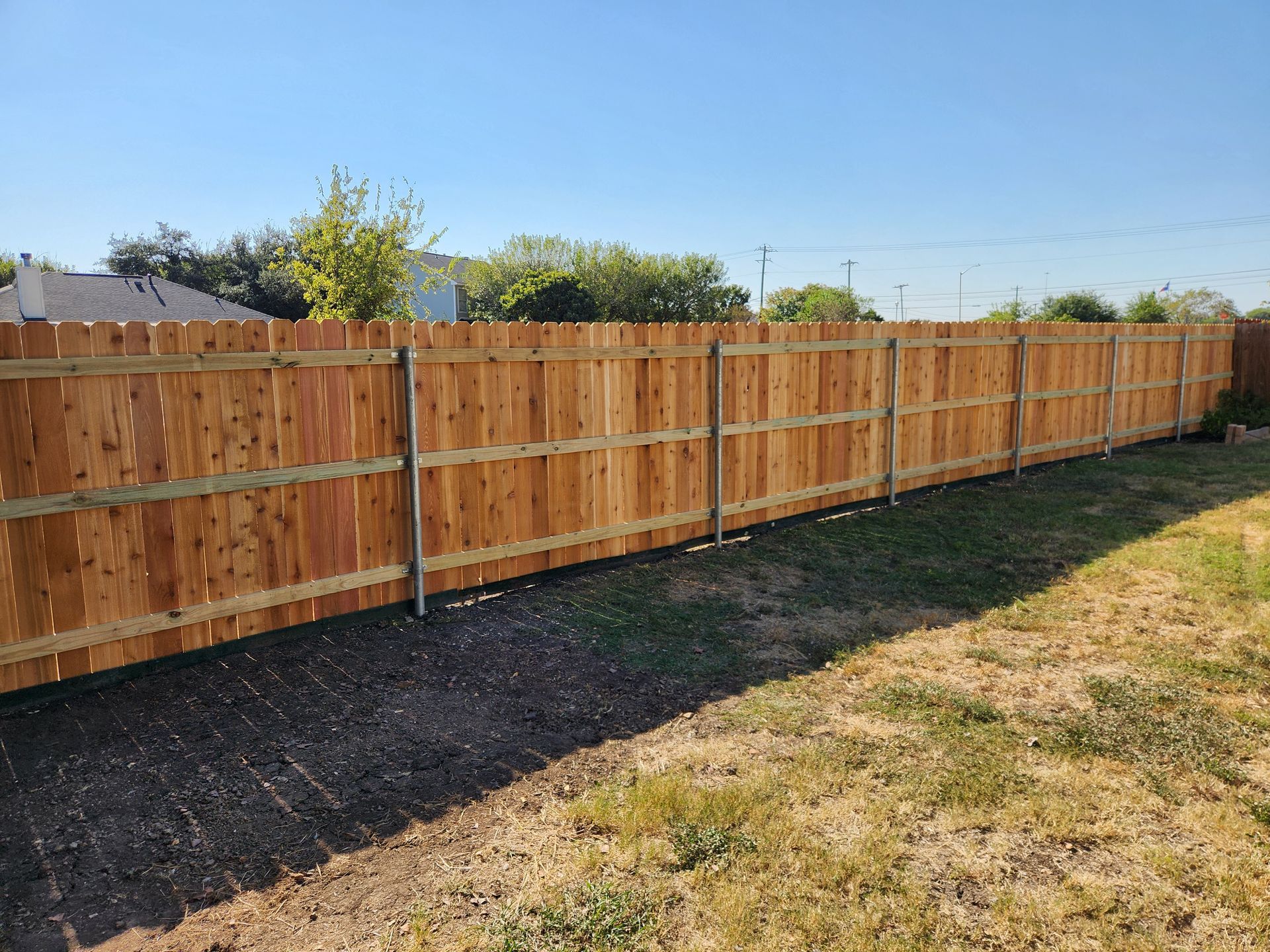 A wooden fence is sitting in the middle of a grassy yard.