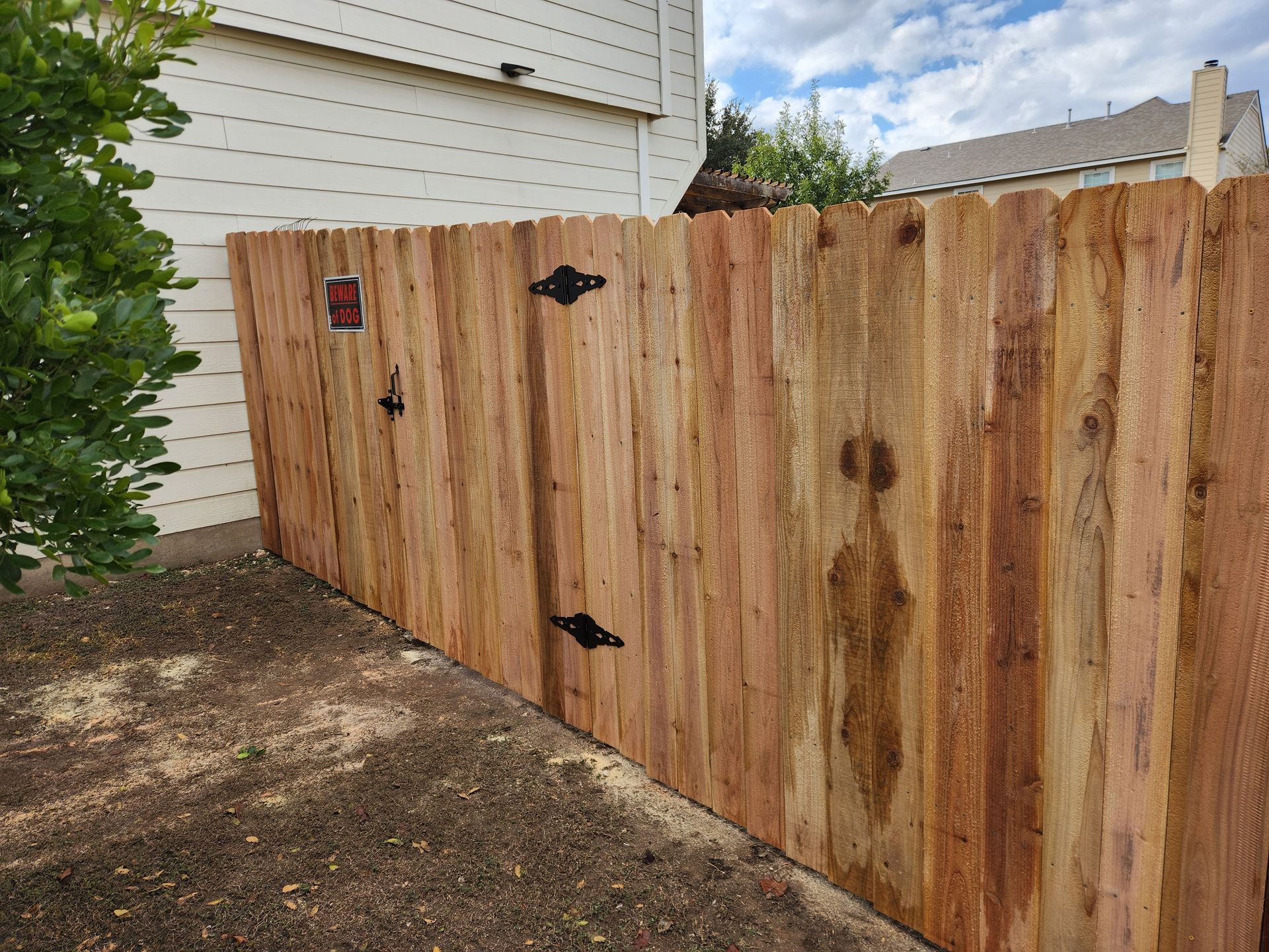 A wooden fence is sitting in front of a house.