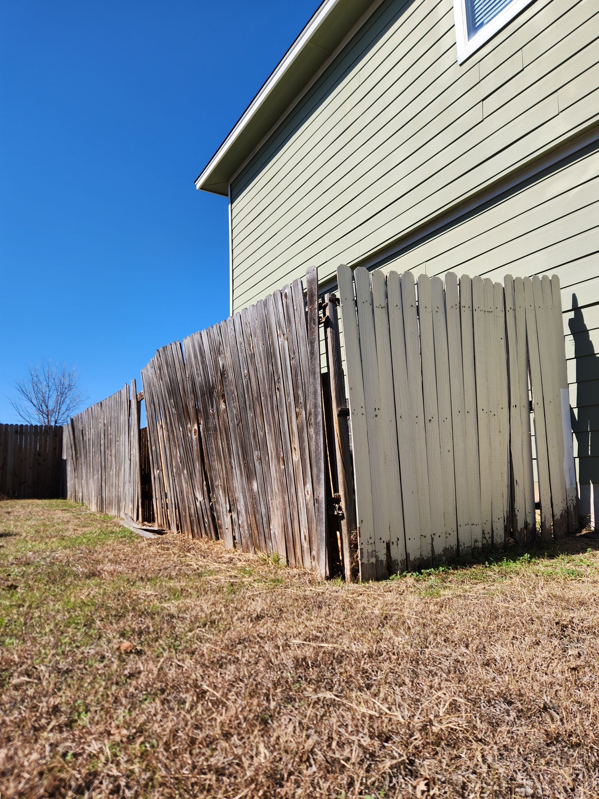 A house with a wooden fence in front of it.