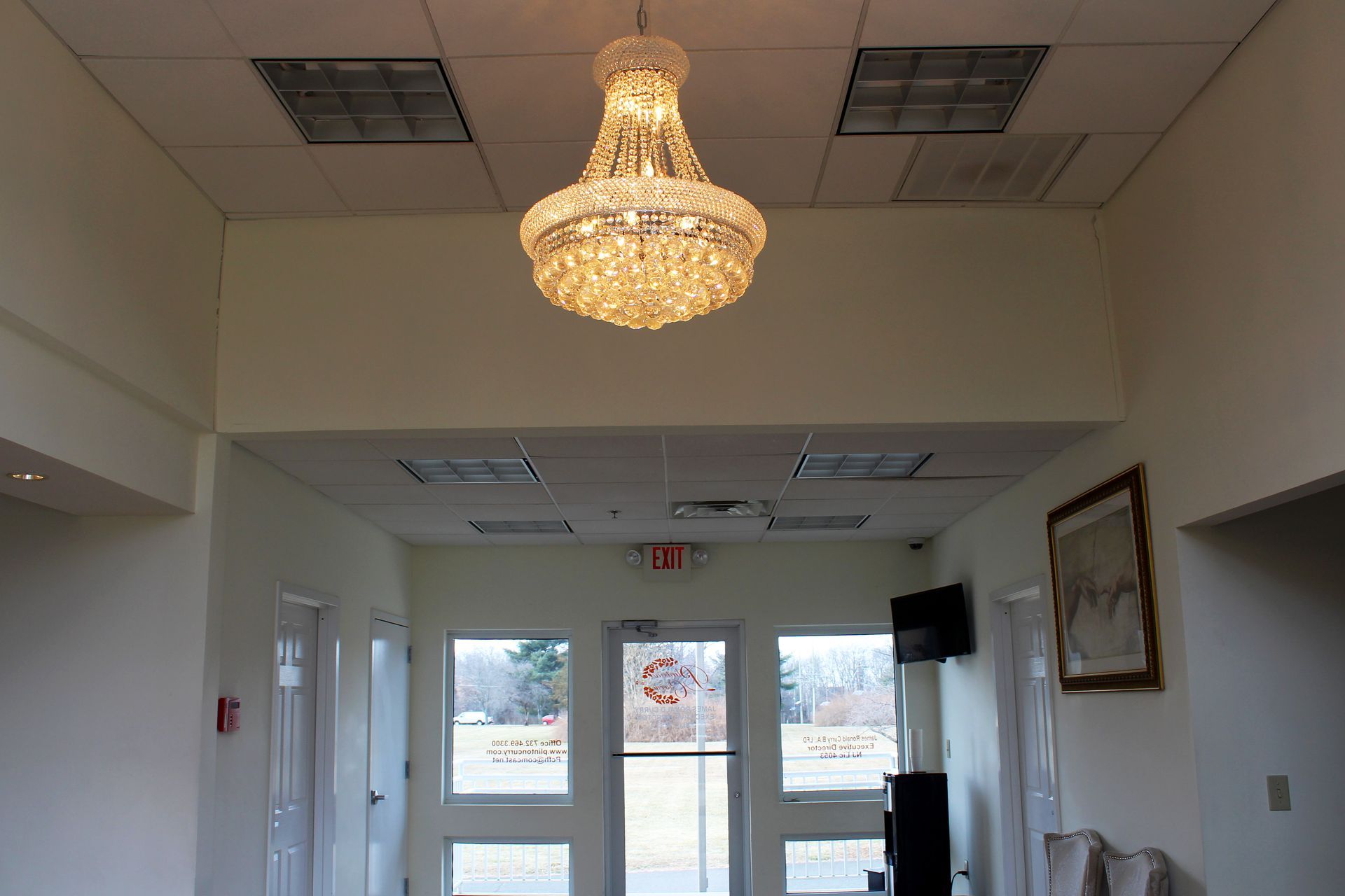 A large chandelier hangs from the ceiling in a hallway