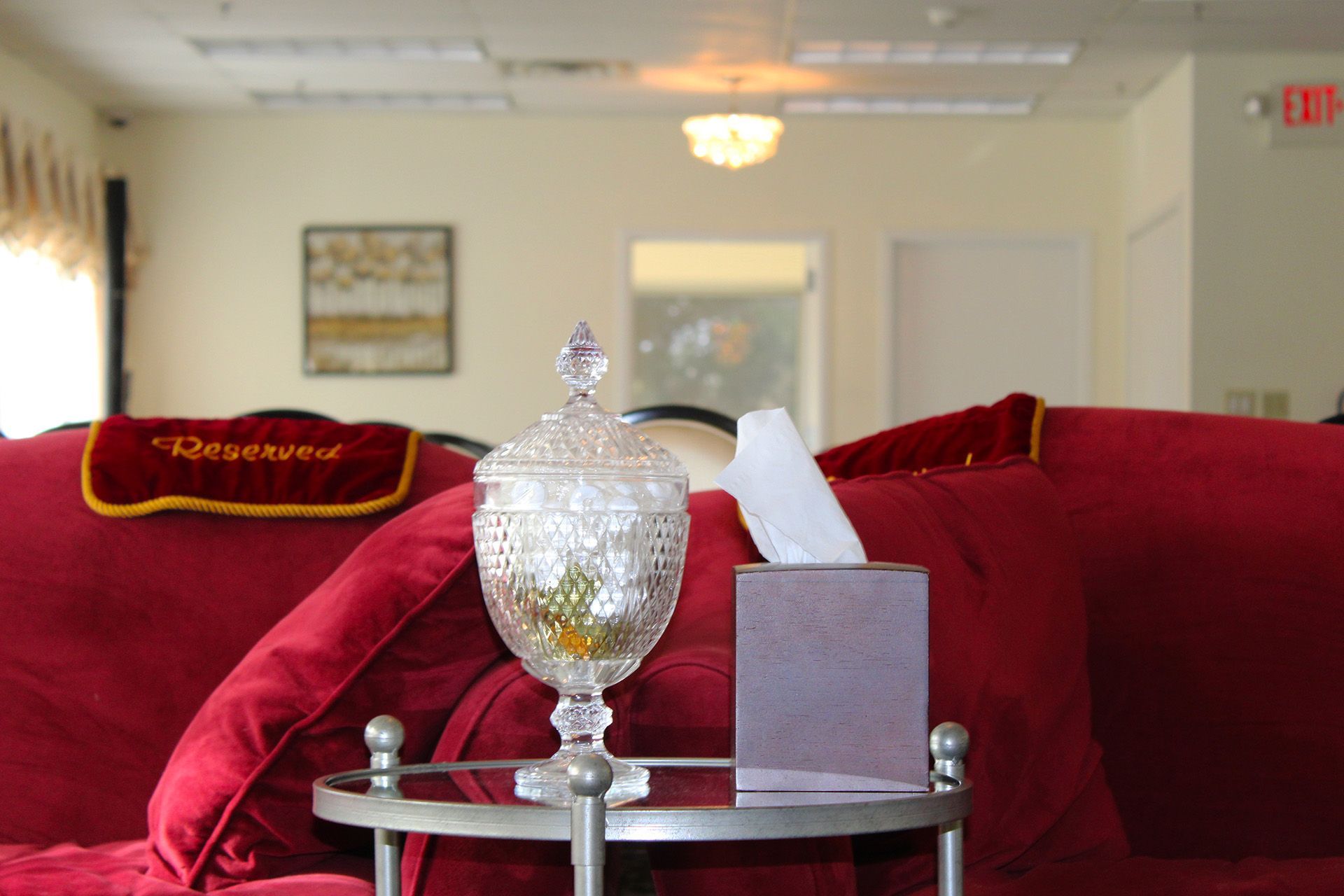 A living room with a red couch and a tissue box on a table