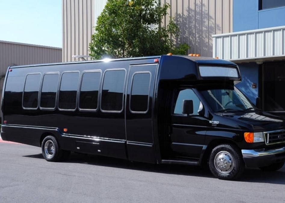 A black bus is parked in front of a building
