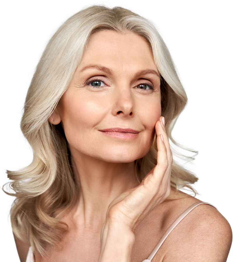A woman is touching her face with her hand and smiling.