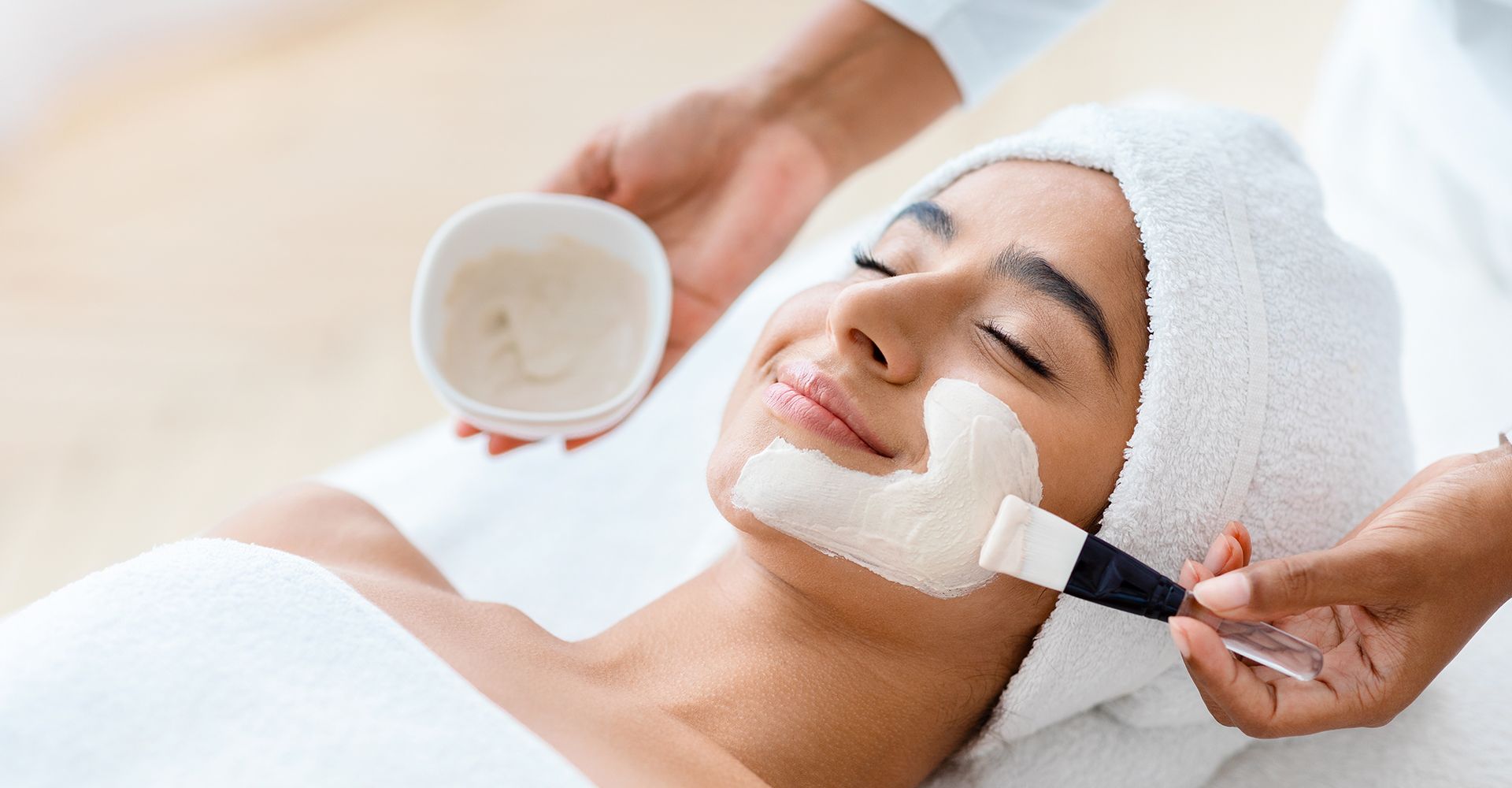 A woman is getting a facial treatment at a spa.