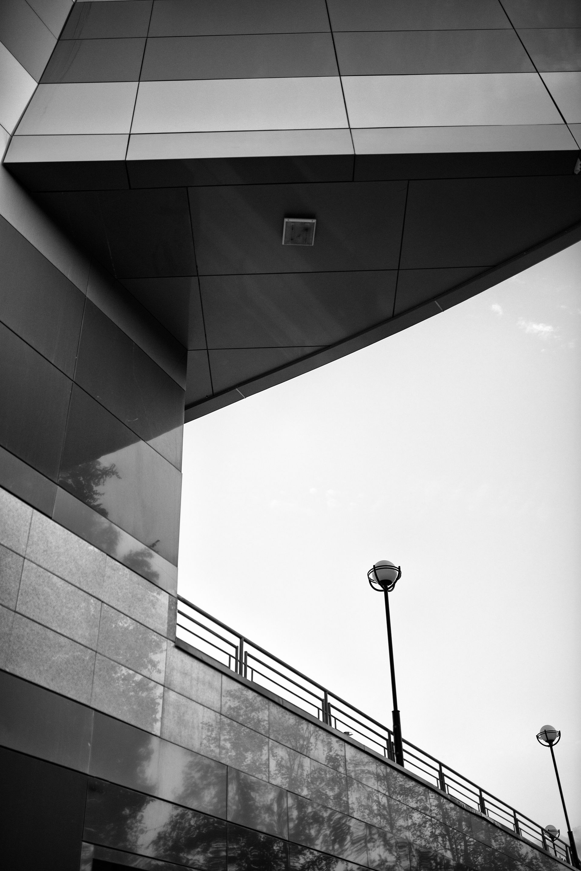 Una foto in bianco e nero di un edificio con un lampione in primo piano