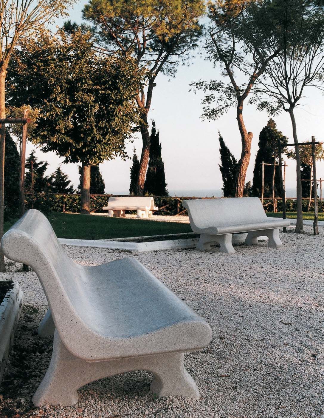 Un parco con due panchine e alberi sullo sfondo