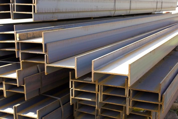 Travi a I in acciaio impilate orizzontalmente, pronte per la costruzione.
