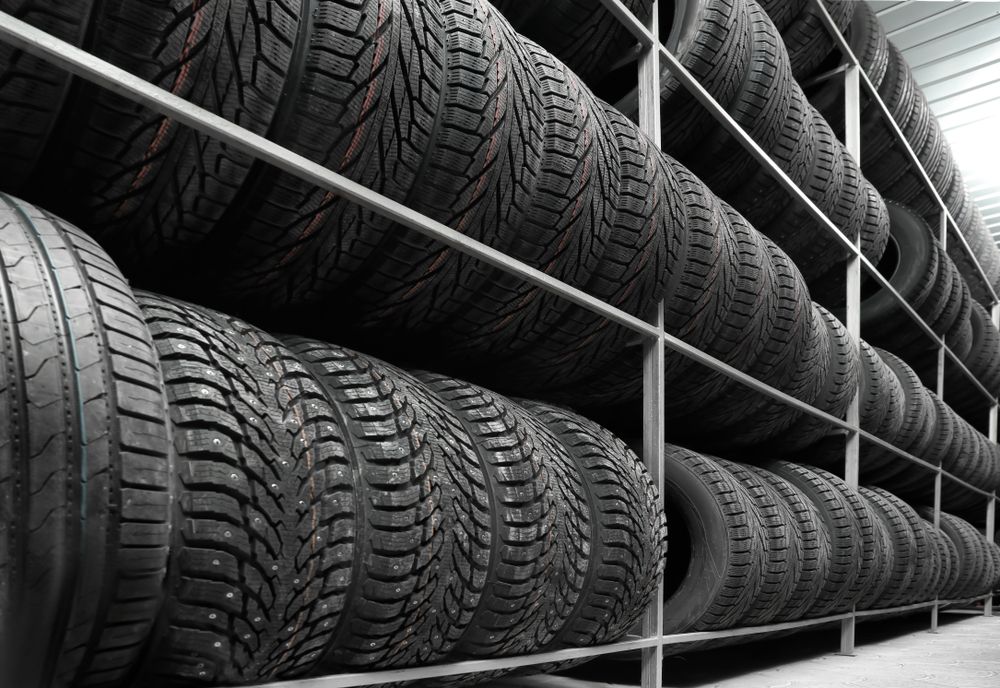 Rows of Black Tires Stacked on Metal Shelving in a Warehouse — Mareeba Tyre Centre in Mareeba, QLD