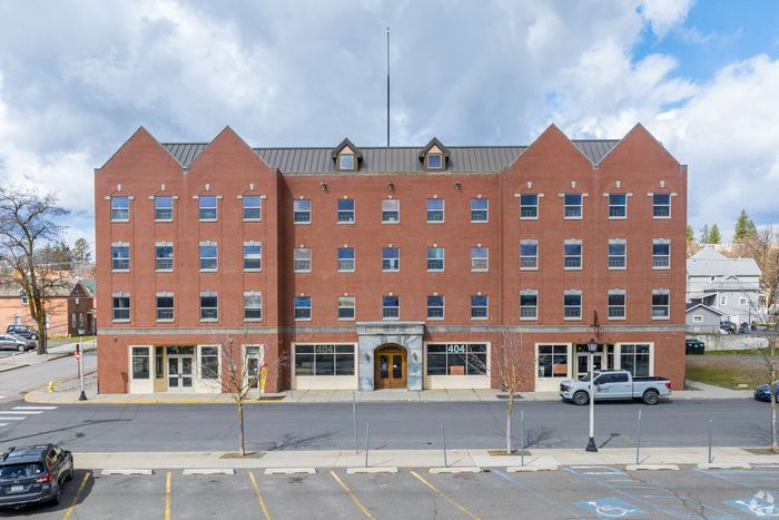 A large brick building with cars parked in front of it.