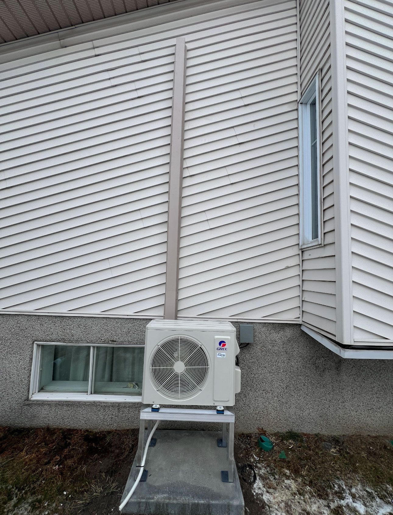 Un climatiseur lg est installé sur le côté d'une maison.