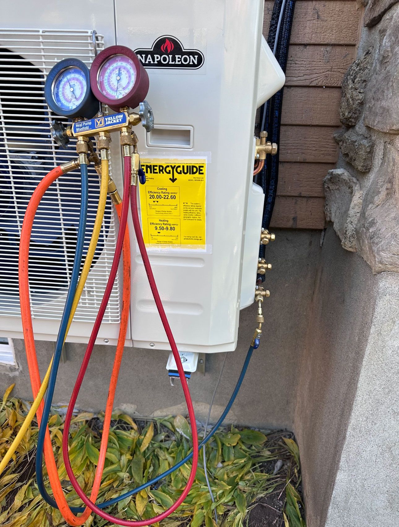 Un climatiseur Napoléon est en cours d'entretien avec un tuyau attaché à celui-ci.