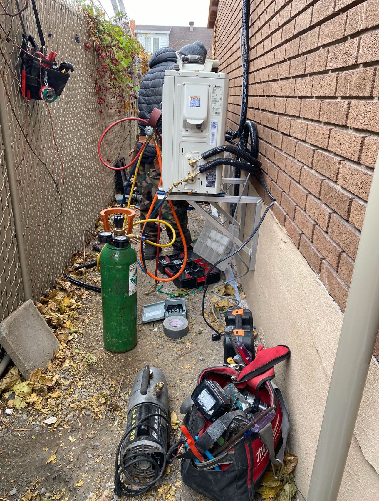 Une pièce avec un mur de briques et un tas d'outils au sol.