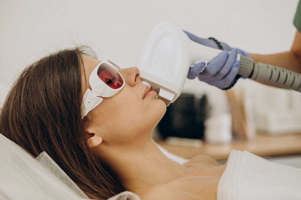 Technician using laser device on face